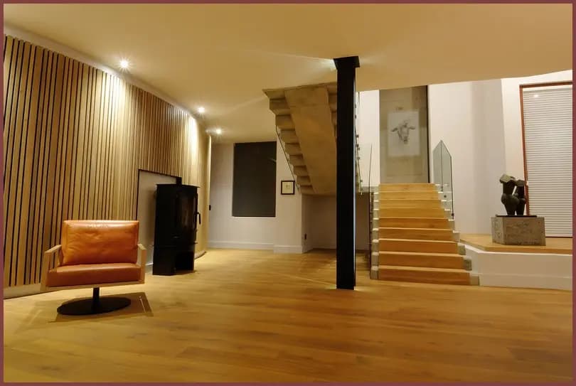 A finished interior with a timber floor, open staircase and a slatted timber feature wall