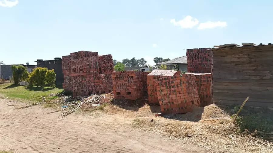 Large stacks of red bricks set down on a cleared building site