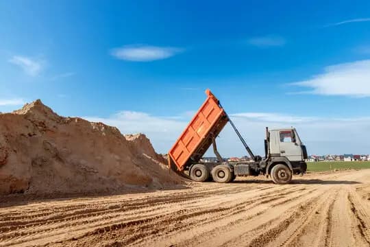 A tipper truck tipping a load of sand