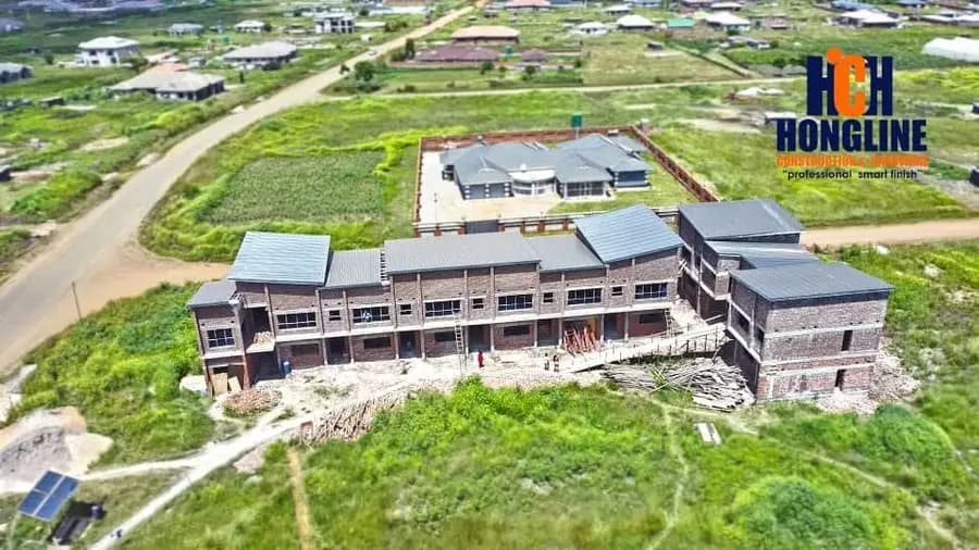 Aerial view of a terrace of townhouses under construction, roofs on and scaffolding still up