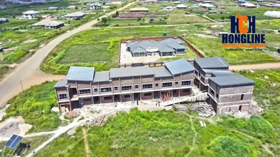 Aerial view of a terrace of townhouses under construction, roofs on and scaffolding still up