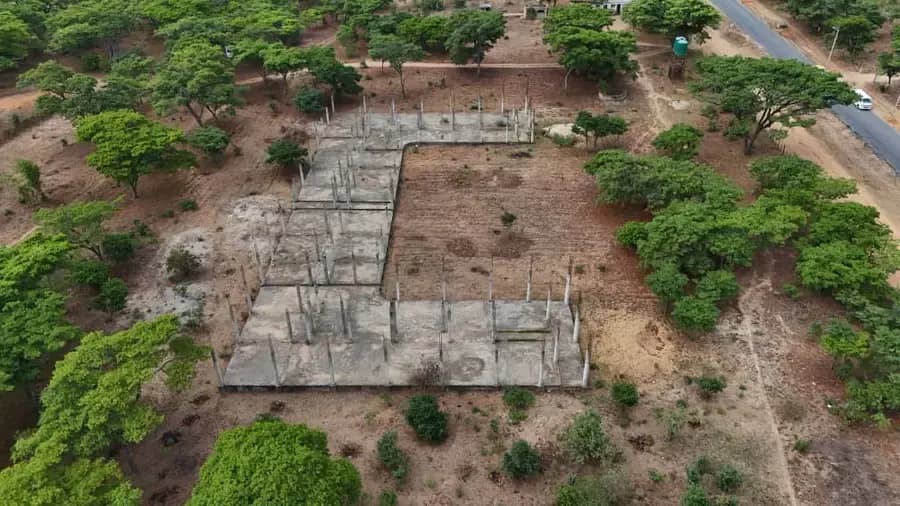 Aerial view of concrete footings laid out in trenches across a cleared plot surrounded by bush