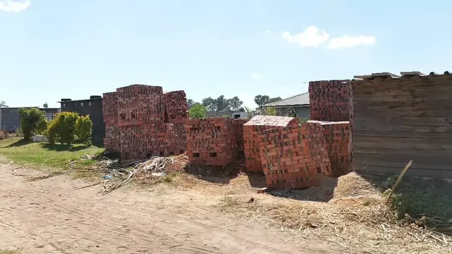 Large stacks of red bricks set down on a cleared building site